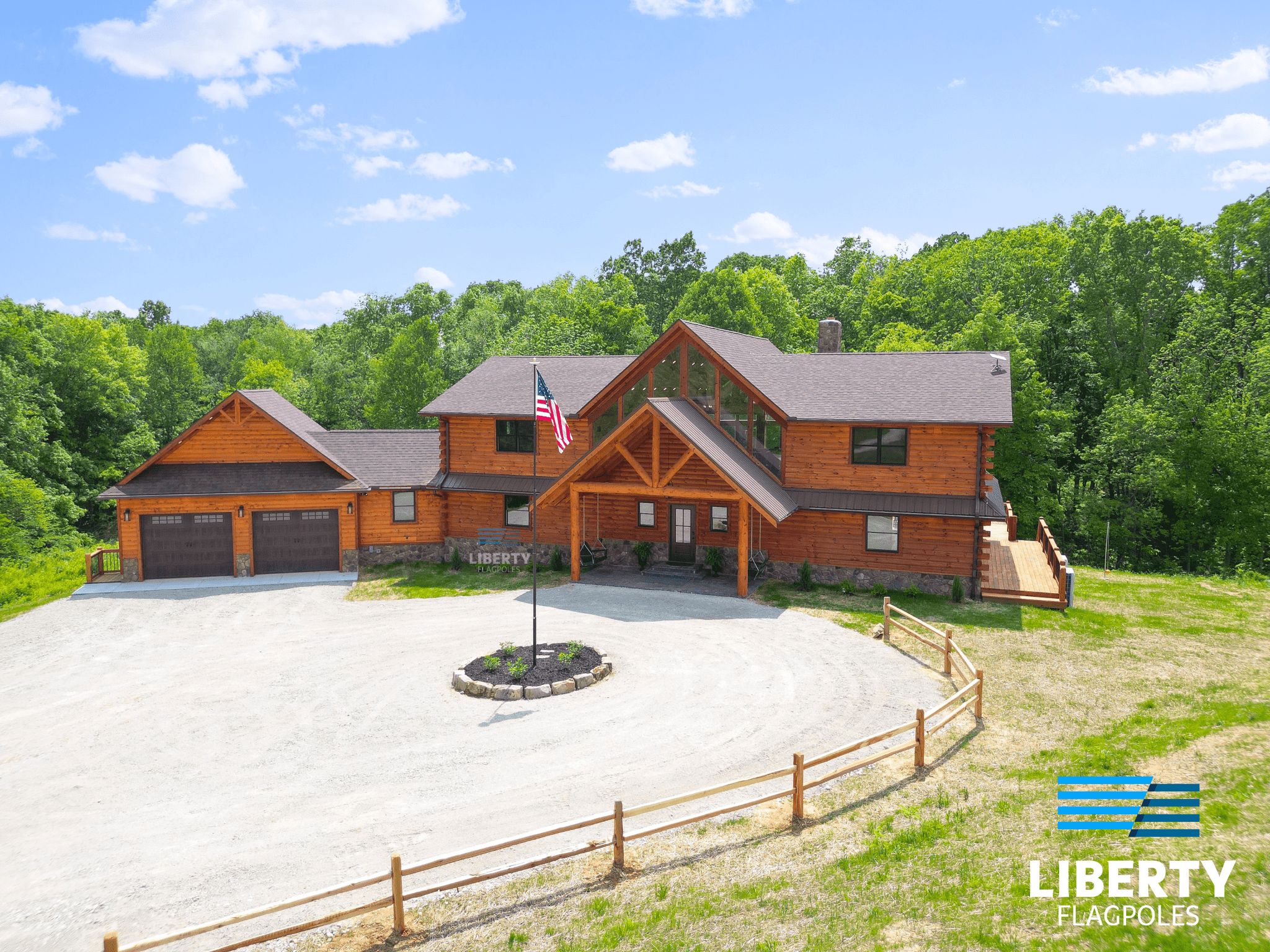 Beautiful log cabin showcasing Liberty Flagpoles american standard heavy duty telescoping flagpole in the circle driveway with landscape center
